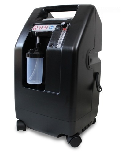 DeVilbiss 5 LPM oxygen concentrator — angled side view with humidifier bottle attached